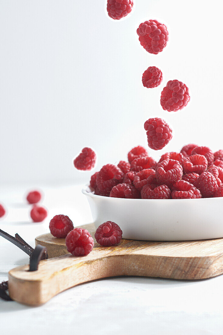 Side view of raspberries in a bowl on a wood isolated on a white background