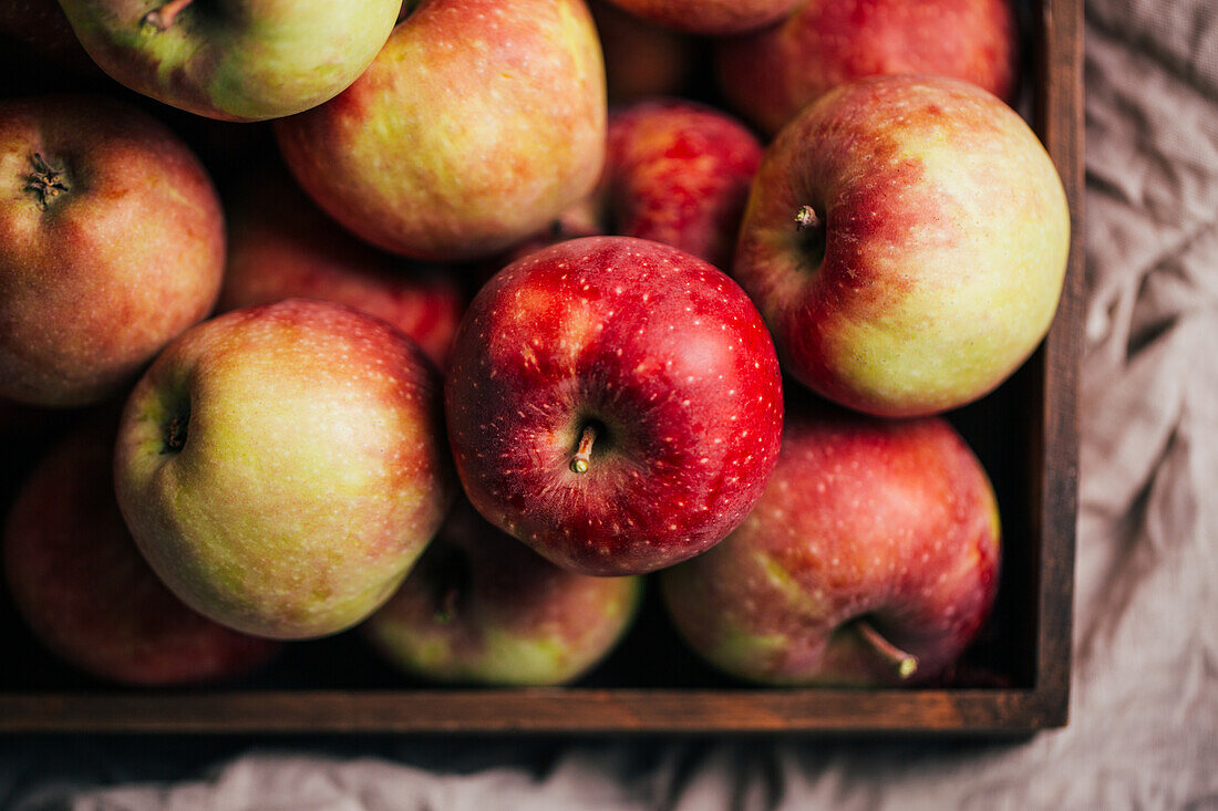 Frische rote Äpfel in einer Schachtel auf einem Tisch