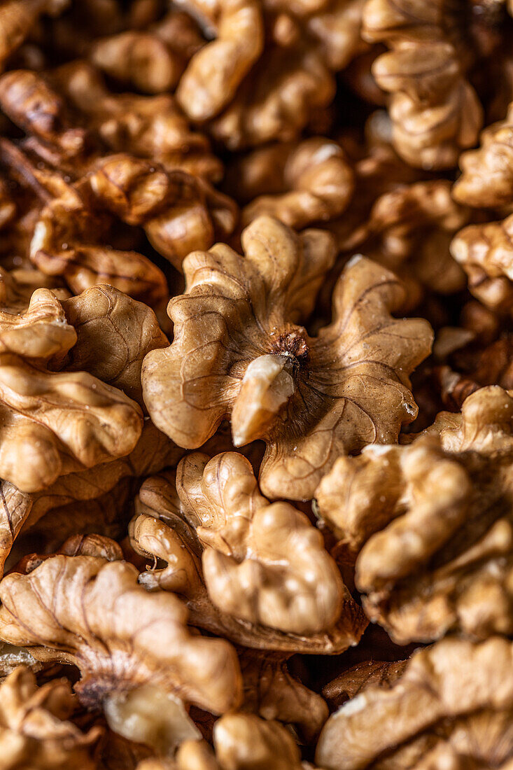 Full frame top view of heap of fresh raw brown crispy walnuts arranged on surface