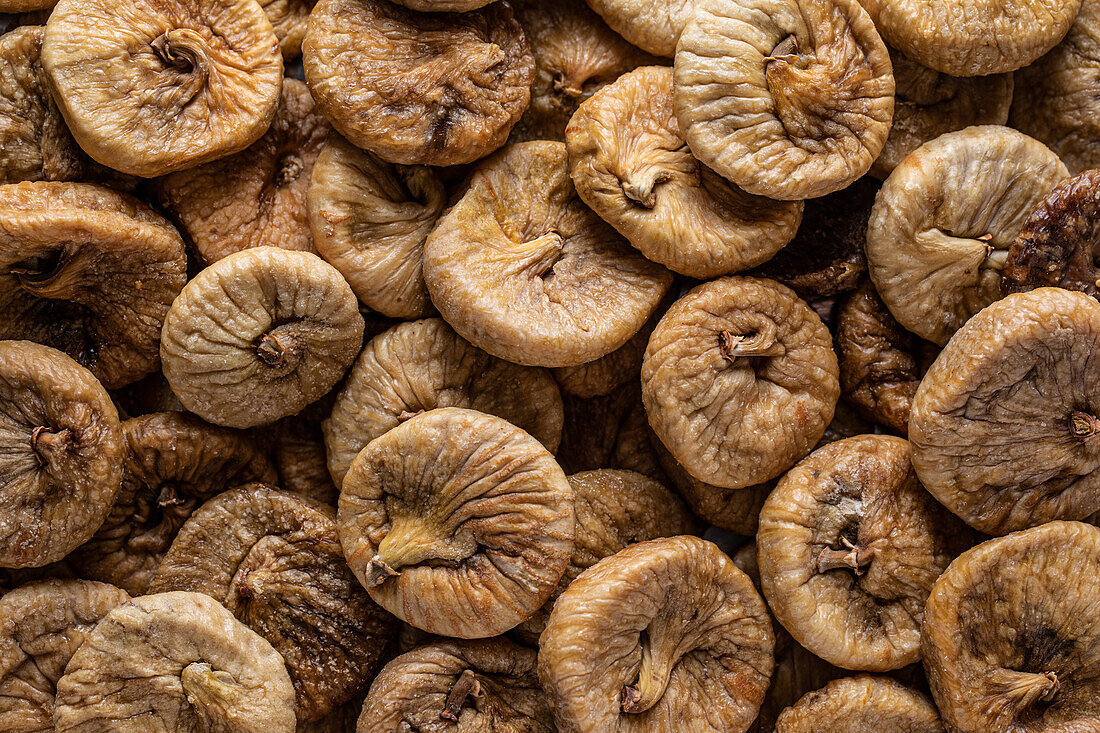 Full frame high angle of shrunken dehydrated Turkish figs stacked in pile on counter