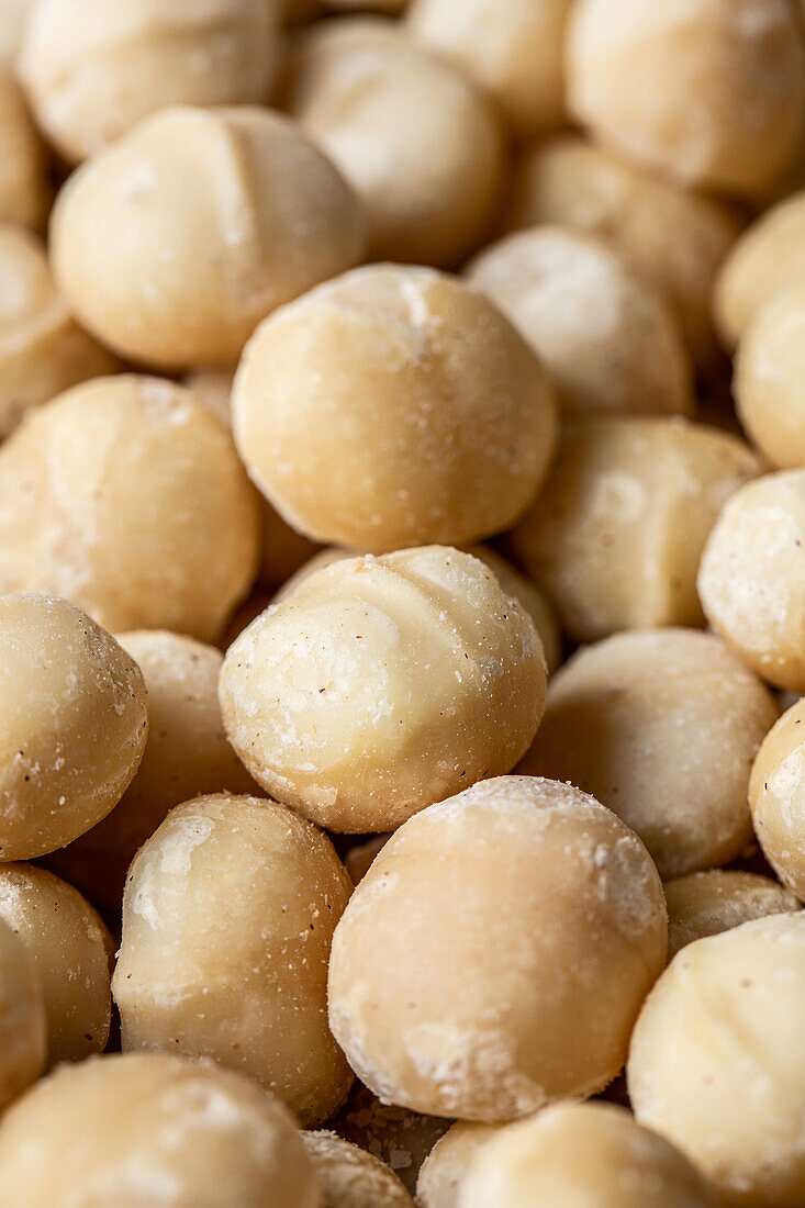 Full frame top view of scattered Macadamia Nuts in sugar powder placed on table