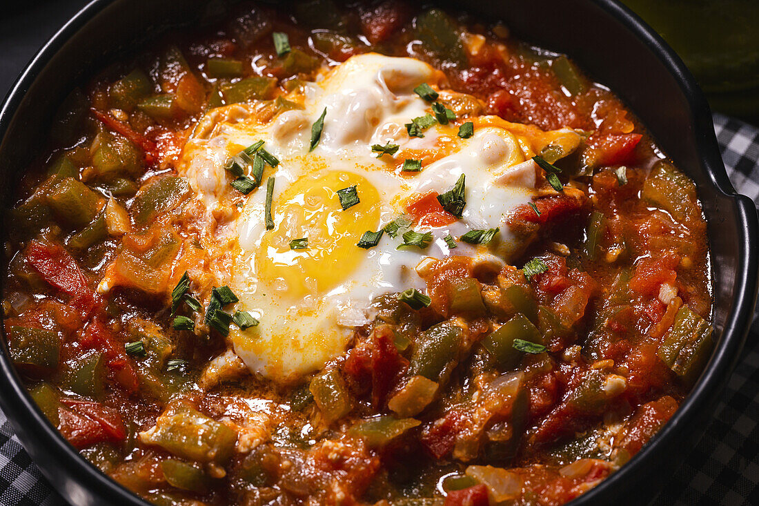 High angle of appetizing traditional Spanish dish made of egg and assorted vegetables and served in bowl on table