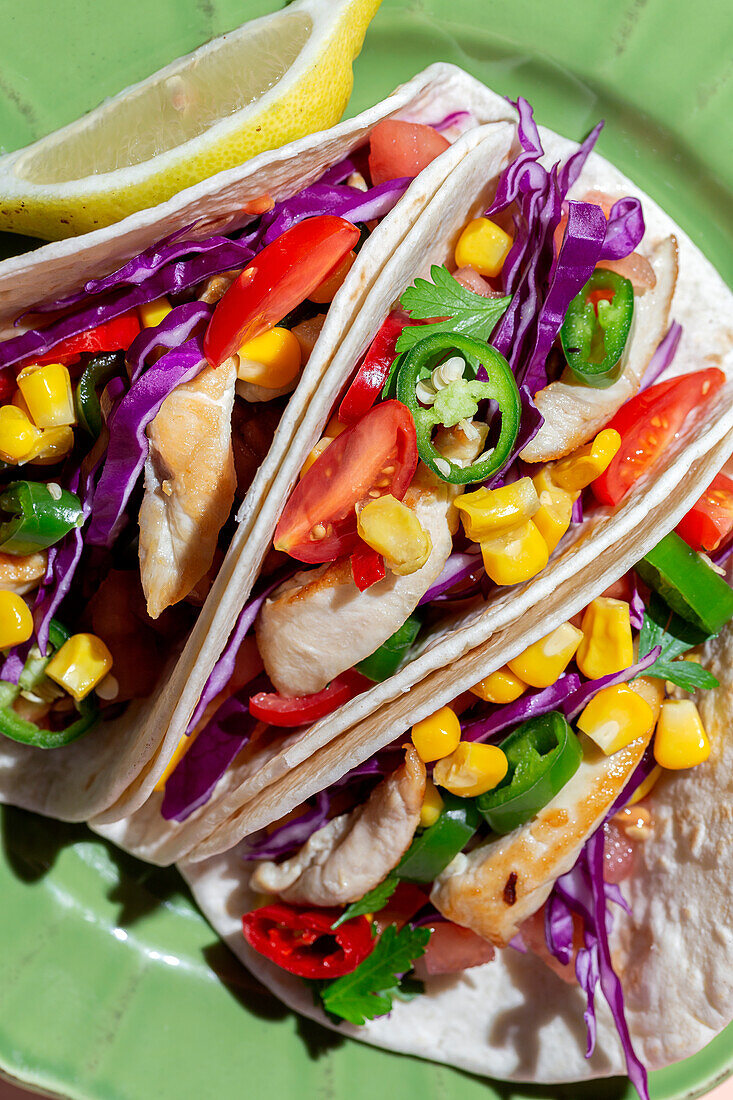Homemade Mexican Tacos with fresh vegetables and chicken with strong light on color background. Healthy food. Typical Mexican