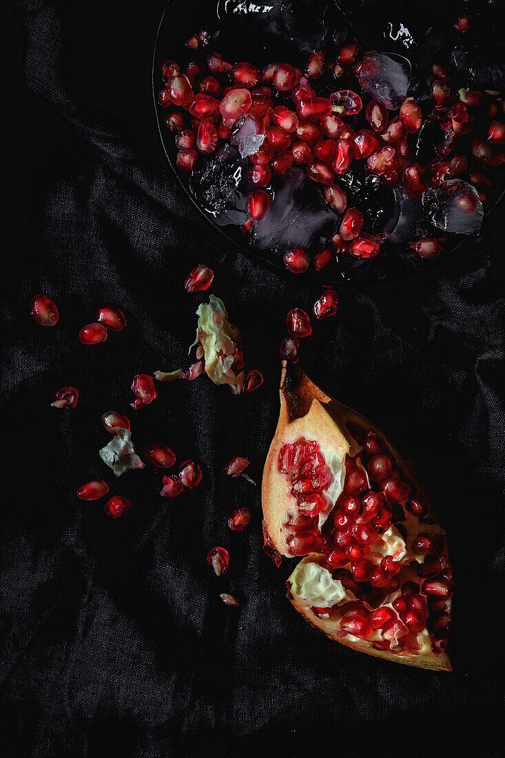 Frischer und roter Granatapfel auf dunklem Hintergrund. Herbstsaison Obst. Top flay; Ansicht von oben