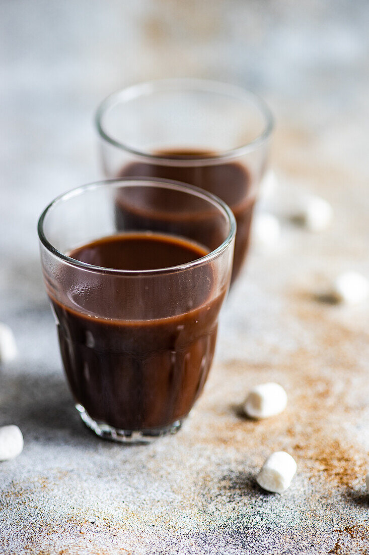 Hot chocolate with mini marshmallow in the glass on concrete background