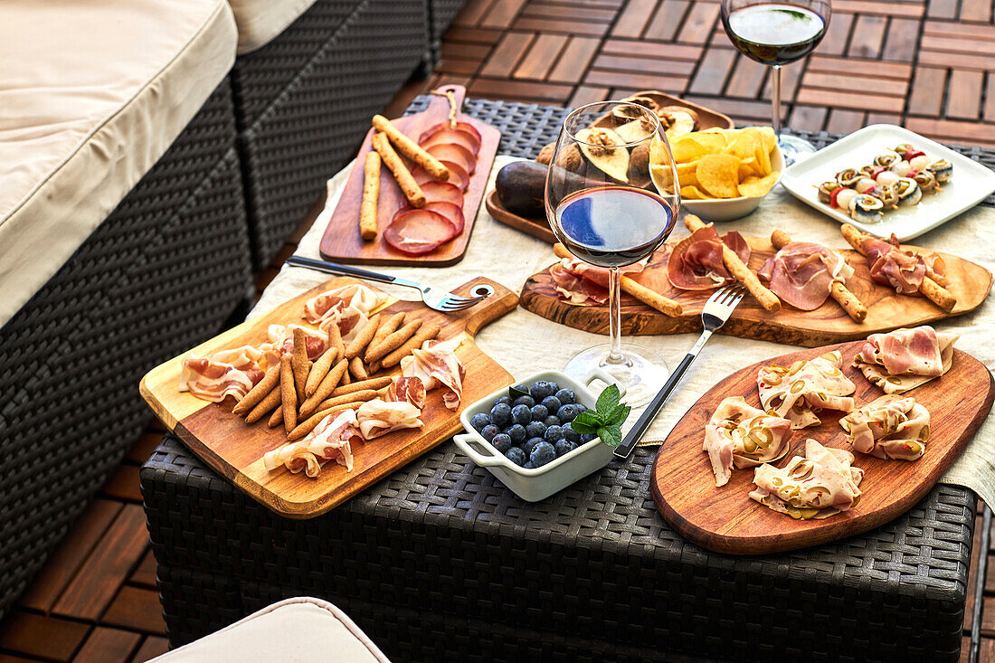 Top view of appetizing antipasto assortment served with plates on table on terrace