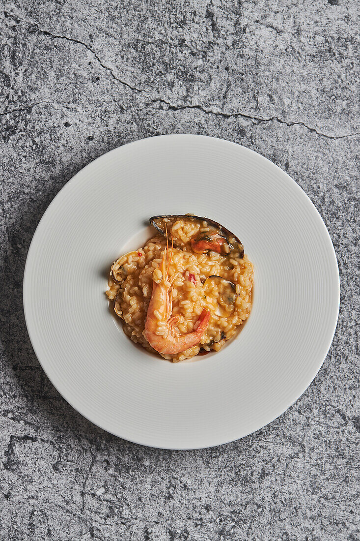 Blick von oben auf appetitlichen Reis mit verschiedenen Meeresfrüchten auf einem Teller in einem Restaurant
