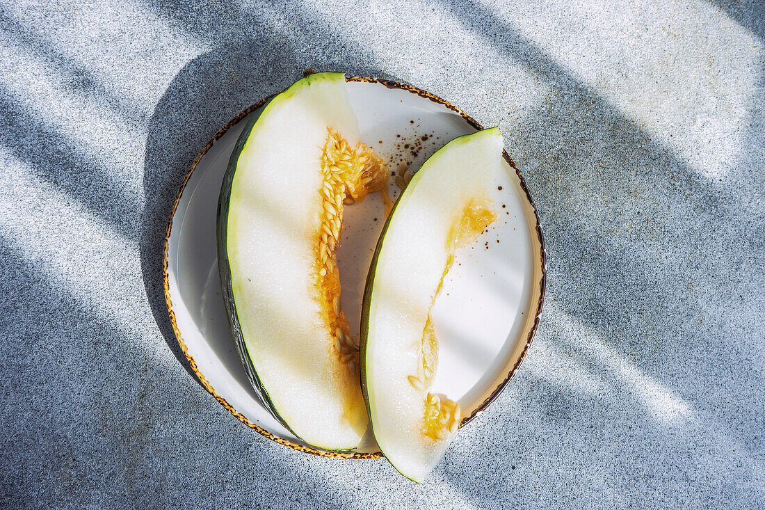 Top view of slices of ripe melon on ceramic plate