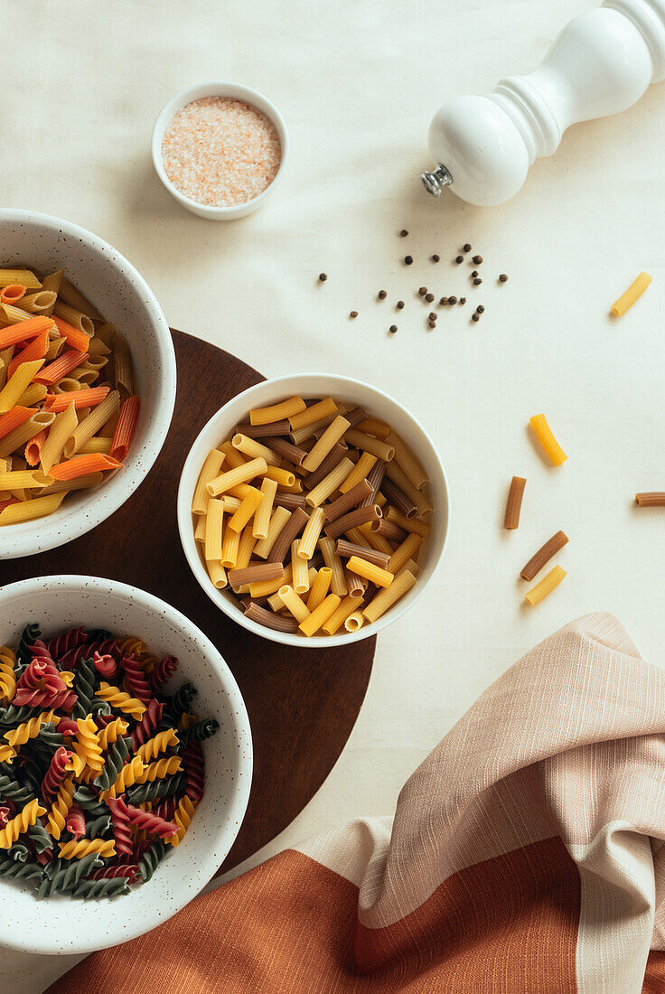 From above different types of pasts in bowls on table with spices