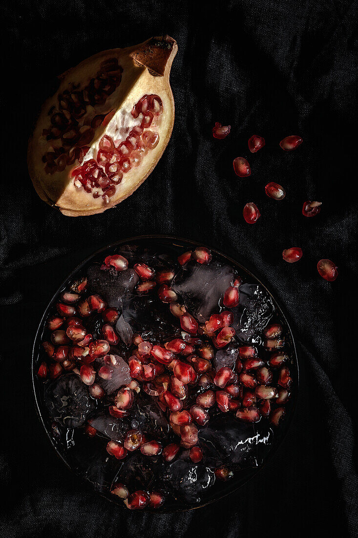 Fresh and red pomegranate on dark background. Fall season fruit. Top flay; top view