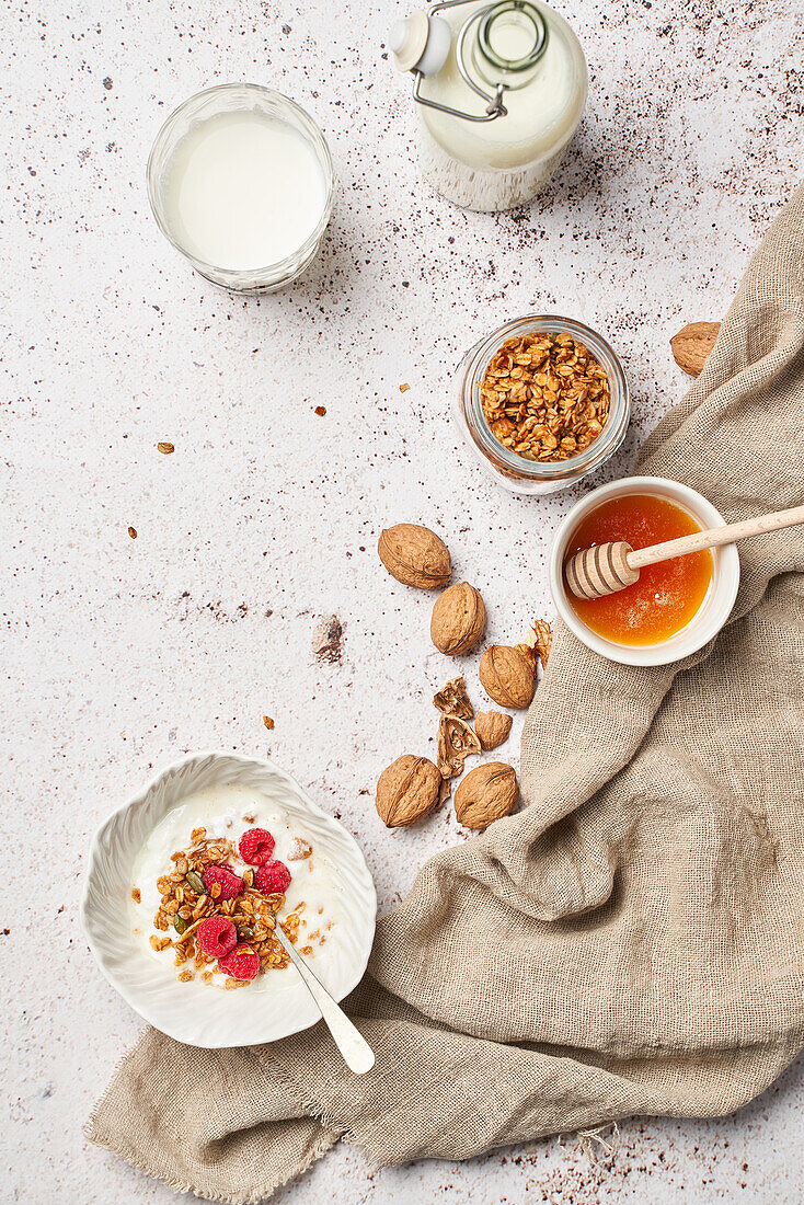 Top view of tasty granola with sweet honey and fresh dairy product served for breakfast