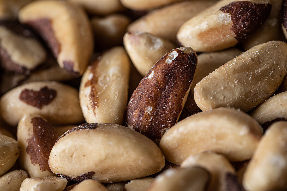 Full frame closeup of delicious raw Brazil nuts with sugar powder scattered on surface