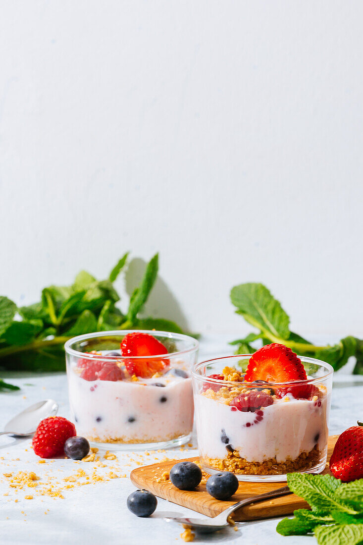 Delicious homemade yogurt with strawberries, berries and cereals on white background