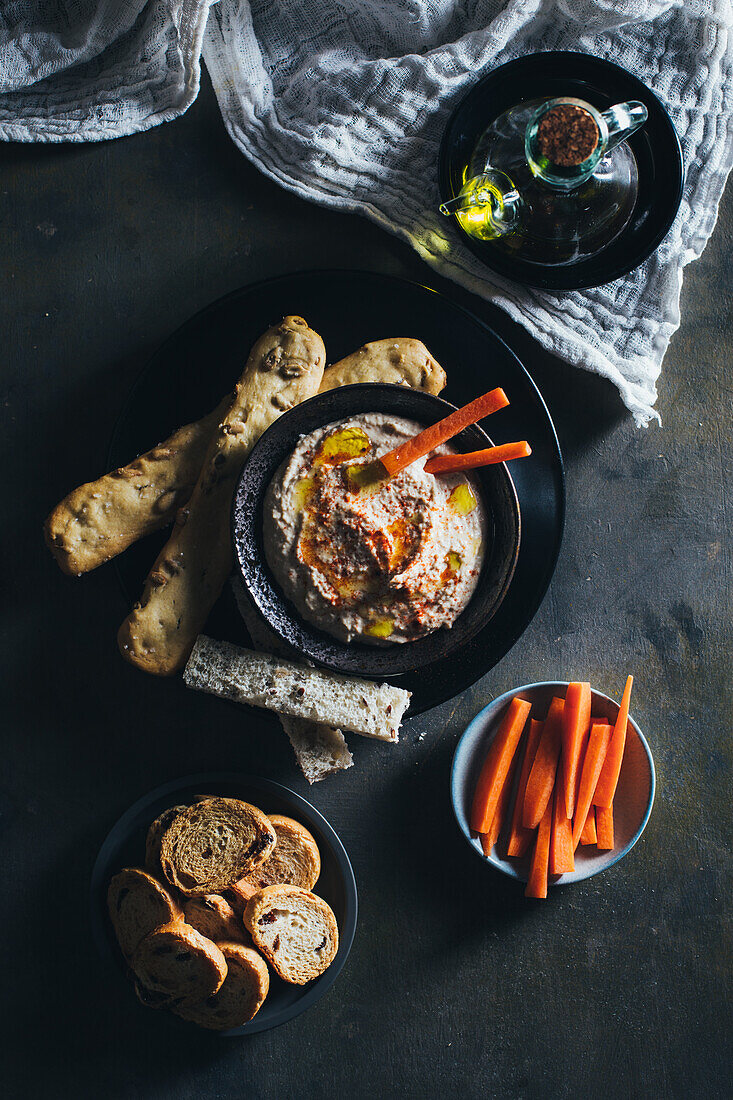 Delicious hummus with paprika, olive oil and some bread to dip