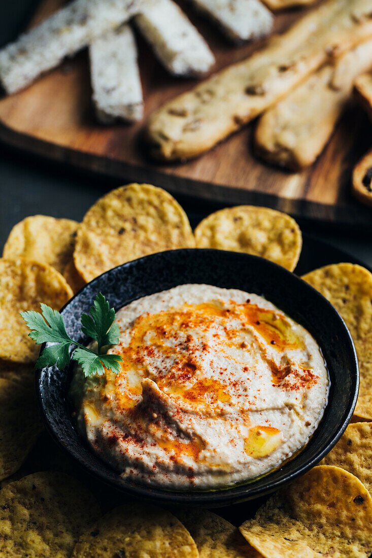 Leckerer Hummus mit Paprika, Olivenöl und etwas Brot zum Dippen