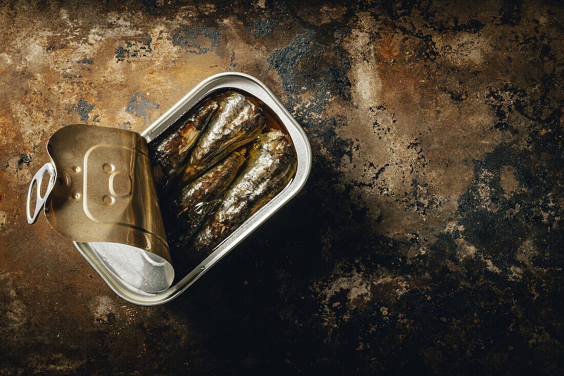 Top view of composition of canned sardines placed against dark background