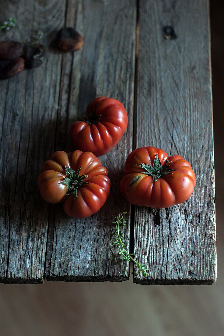 From above of ripe red tomatoes with striped napkin on wooden table