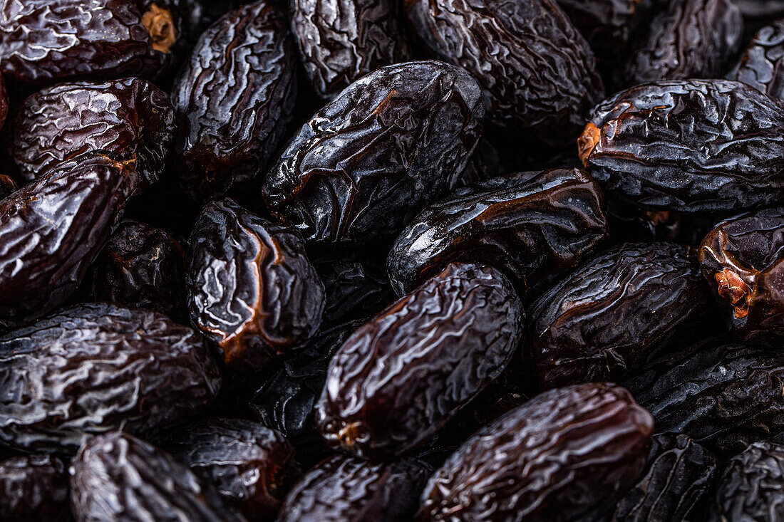 Full frame background top view of pile of appetizing dried date medjoul fruits arranged on surface