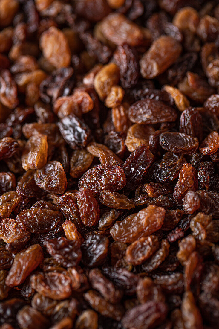 Full frame top view of heap of sweet multicolored dried sultana raisins placed on table