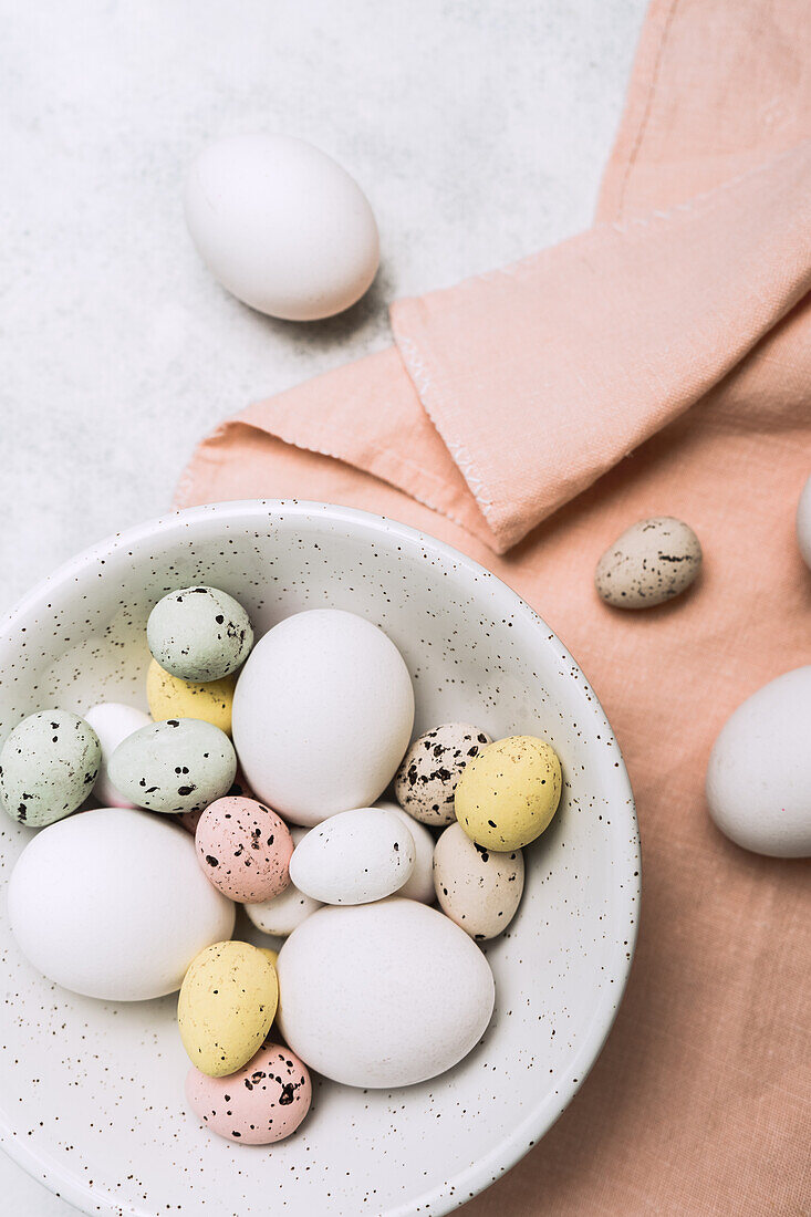 From above still life of beautiful painted Easter eggs over white table background