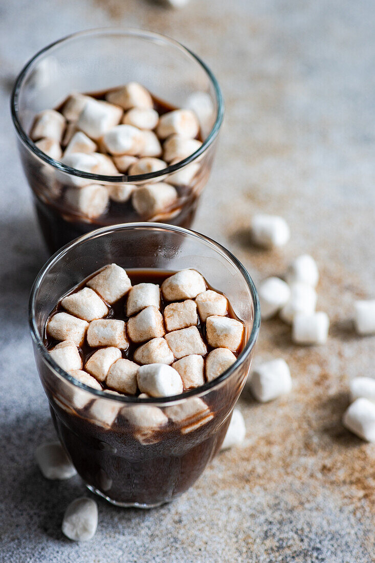 Heiße Schokolade mit Mini-Marshmallow im Glas auf Betonhintergrund