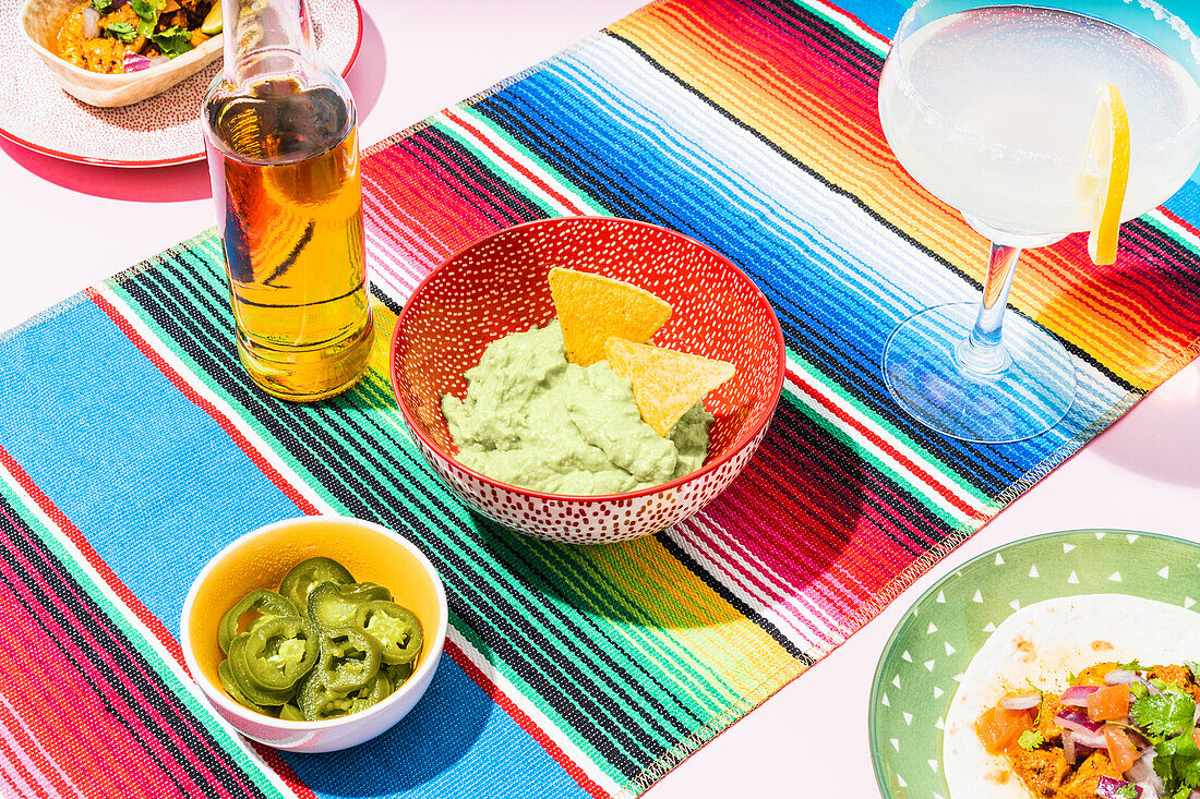 Von oben Flasche Bier und Glas Limonade neben verschiedenen Gerichten der mexikanischen Küche auf dem Tisch