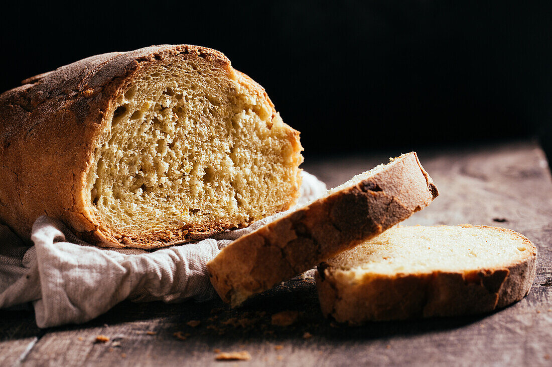 Frisch gebackener Brotlaib auf dem Holztisch in der Küche an einem sonnigen Tag