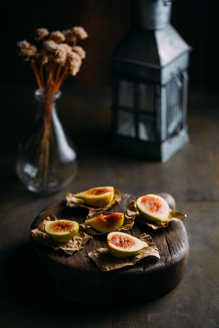Top view of fresh sweet figs arranged on wooden chopping board on dark background