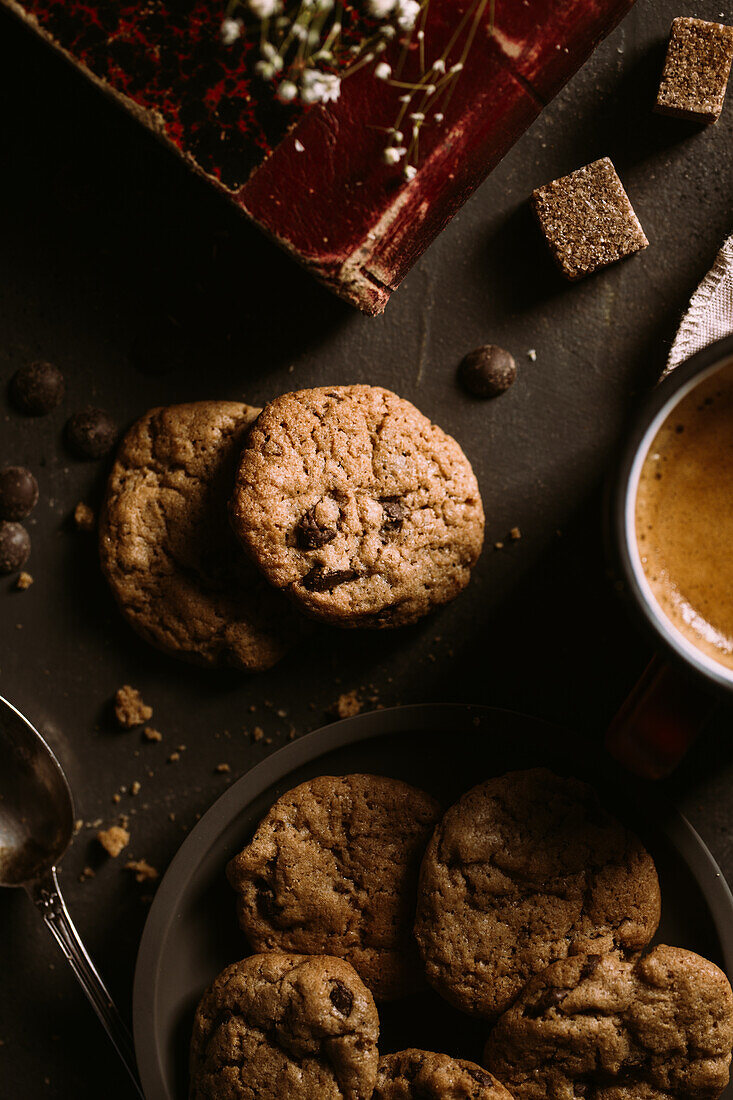 Homemade chocolate chips cookies on a old vintage book served with coffee on a mug