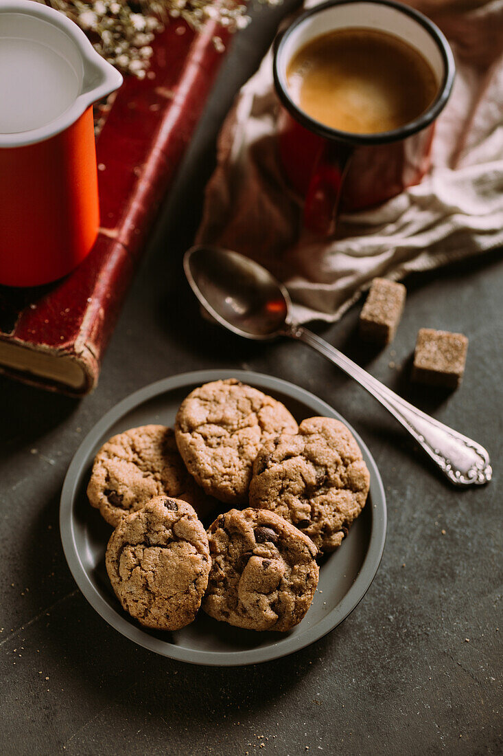 Homemade chocolate chips cookies on a old vintage book served with coffee on a mug