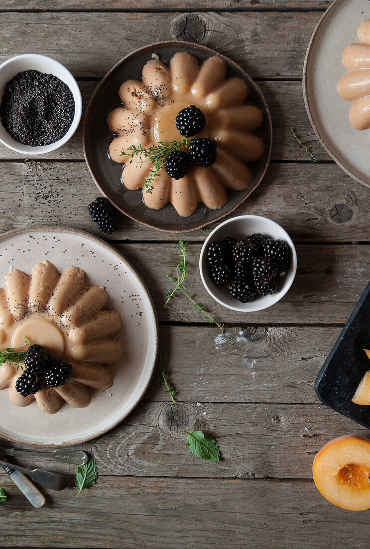 Flat lay of arranged served panna cotta with peach and poppy seeds on table with blackberry