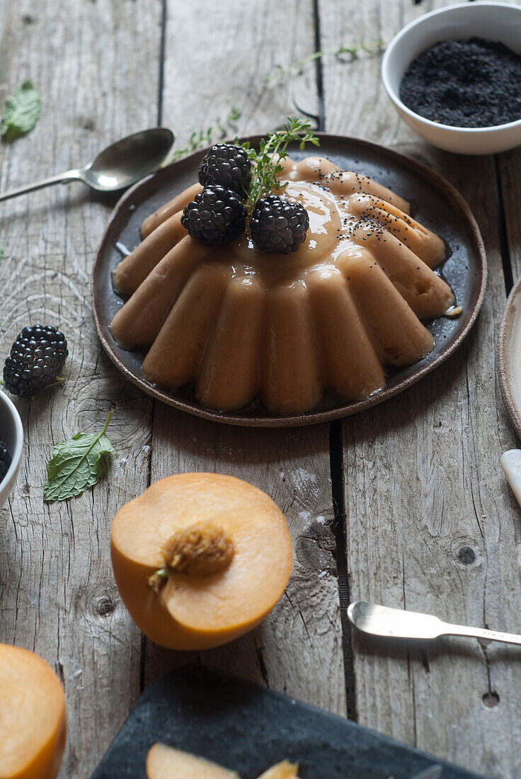 Closeup of served vegan panna cotta with peach and shiny sweet blackberry