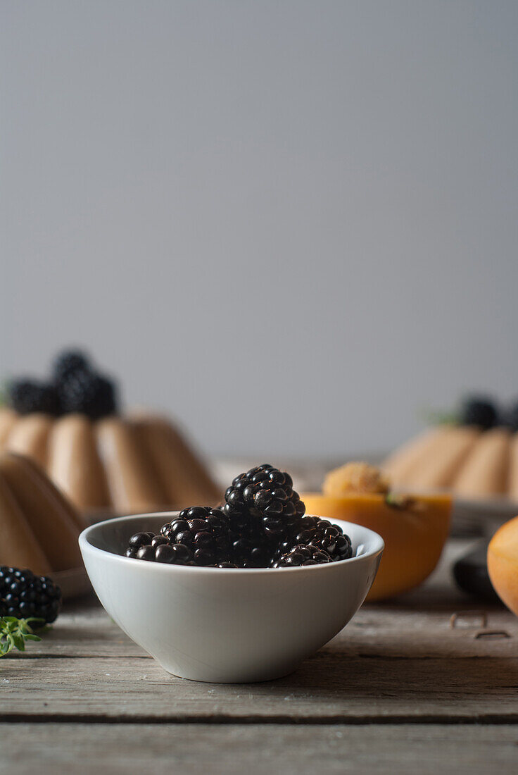 Closeup of served vegan panna cotta with peach and shiny sweet blackberry