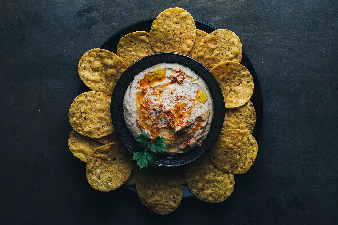 Leckerer Hummus mit Paprika, Olivenöl und etwas Brot zum Dippen