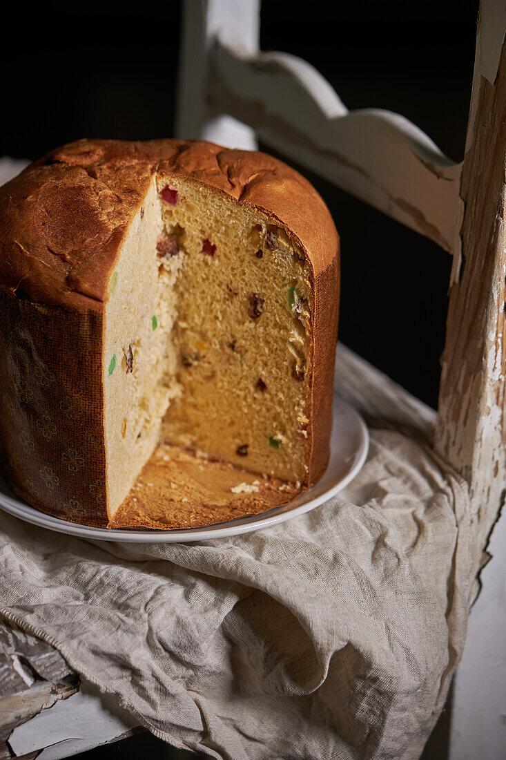 Blick von oben auf frisch gebackenen Panettone-Kuchen auf einem alten Holzstuhl