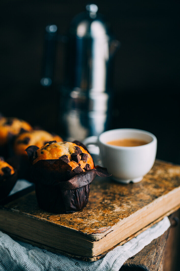 Chocolate muffins and coffee cup on dark background