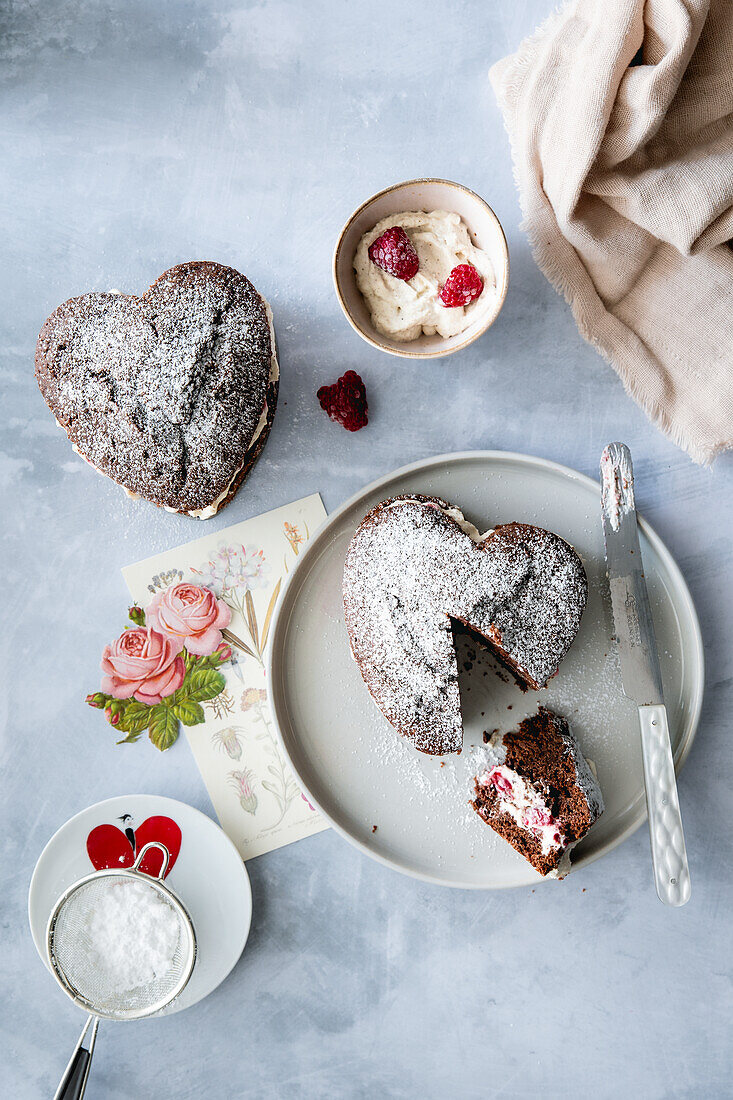 Heart-shaped chocolate cake with vanilla cream and raspberries