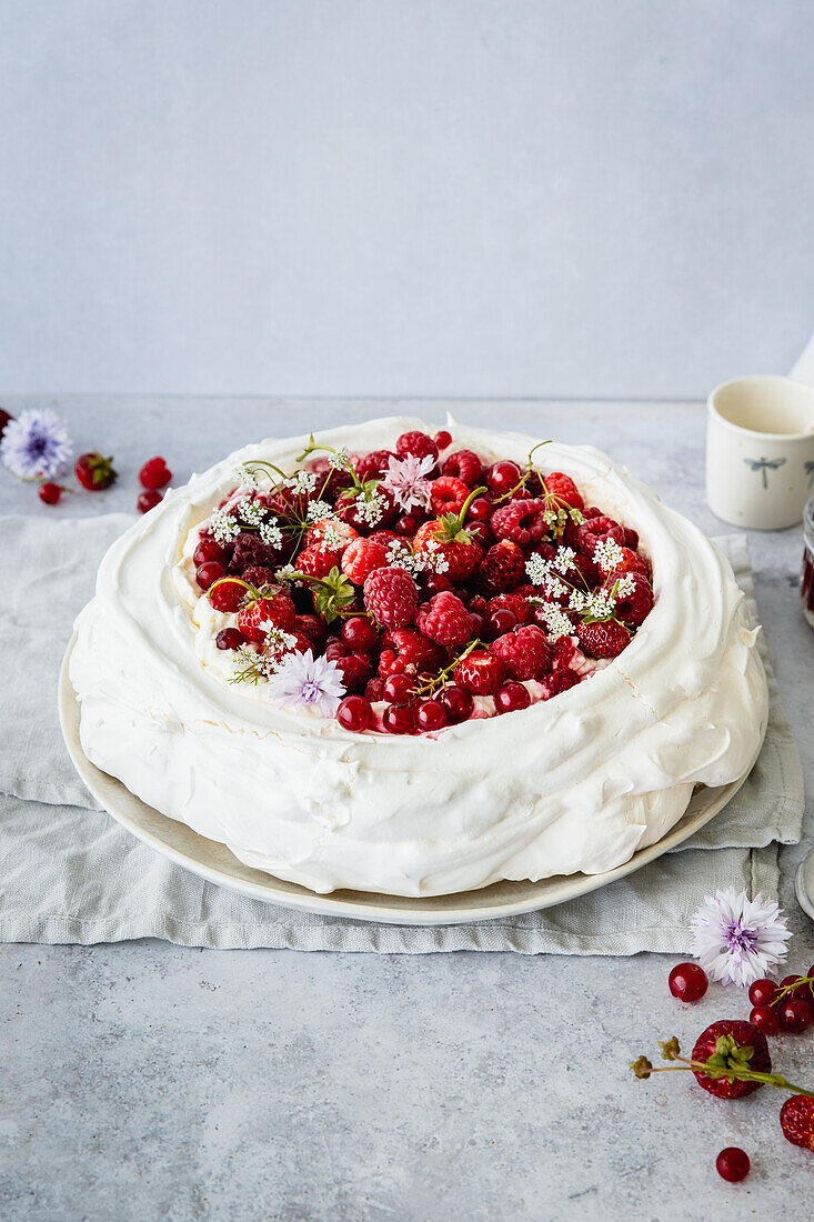 Pavlova with red summer berries and cream