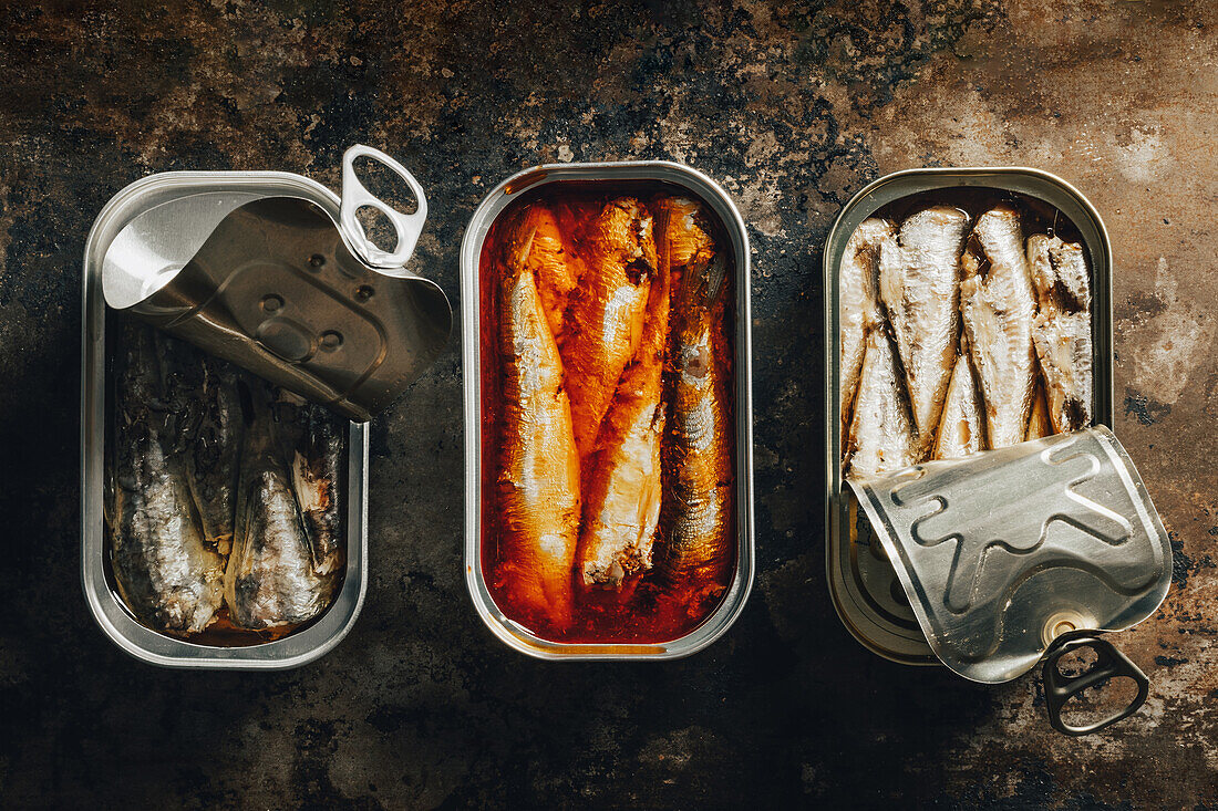 Top view of composition of canned sardines placed against dark background