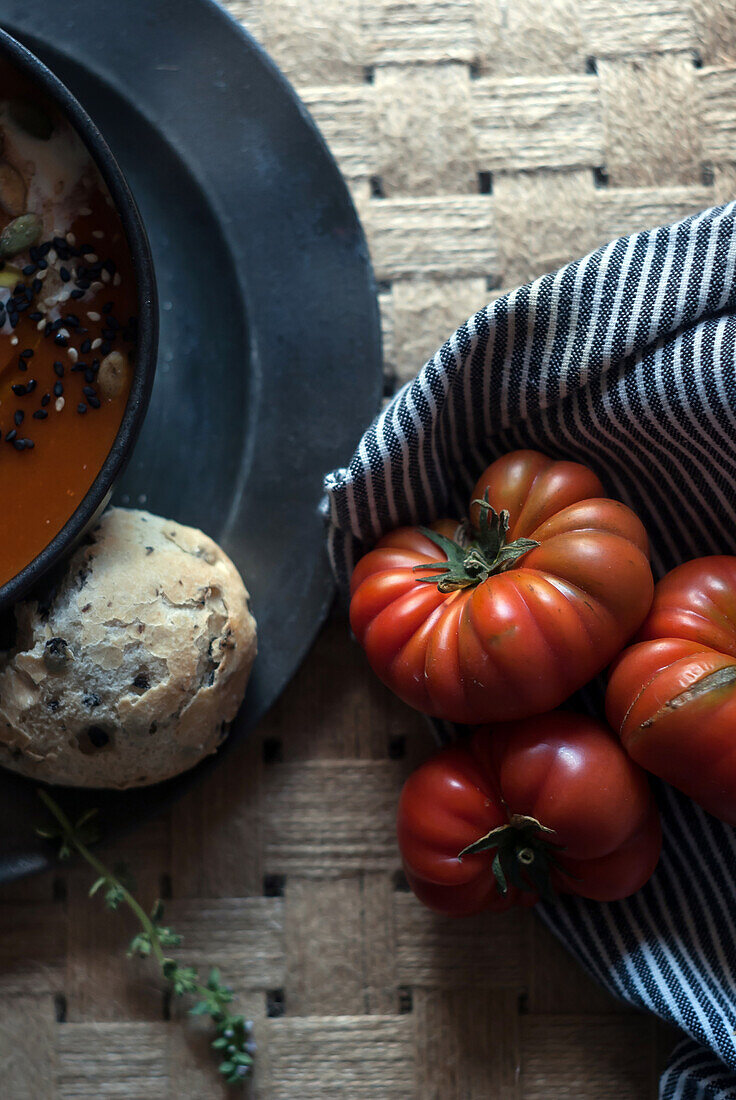 From above of ripe red tomatoes with striped napkin on wooden table