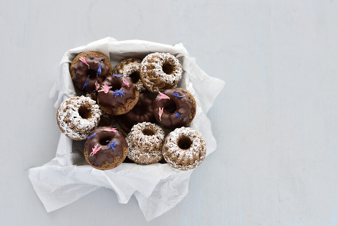 Vegan mini almond bundt cakes with chocolate icing and icing sugar