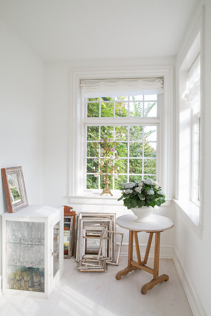 Bright room with round table and old picture frames