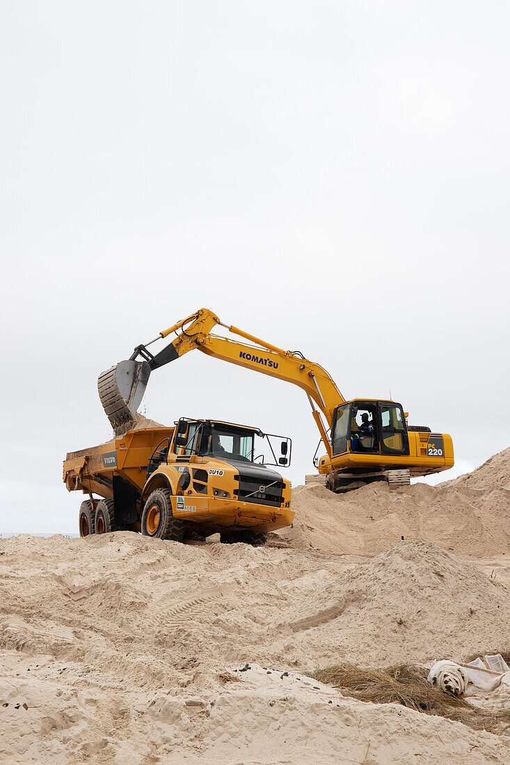 Coastal dunes being reshaped by mechanical digger