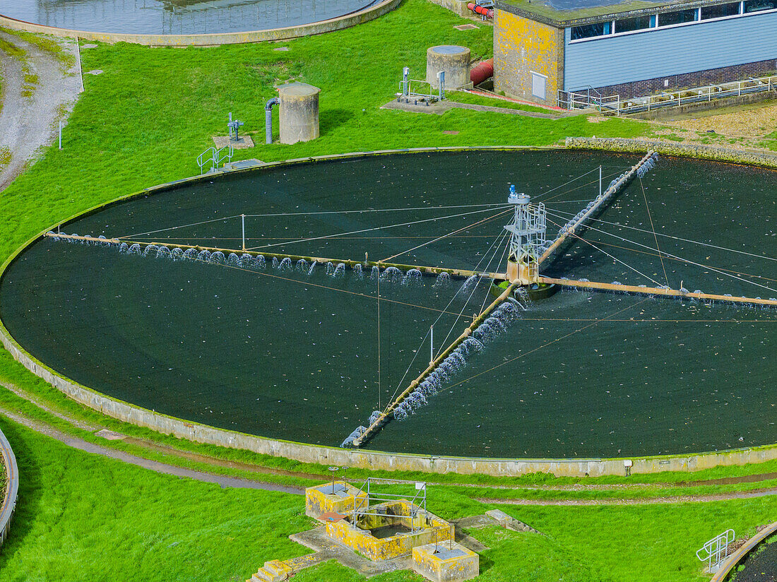 Aerial view of sewage farm on bank of flooded River Avon, UK