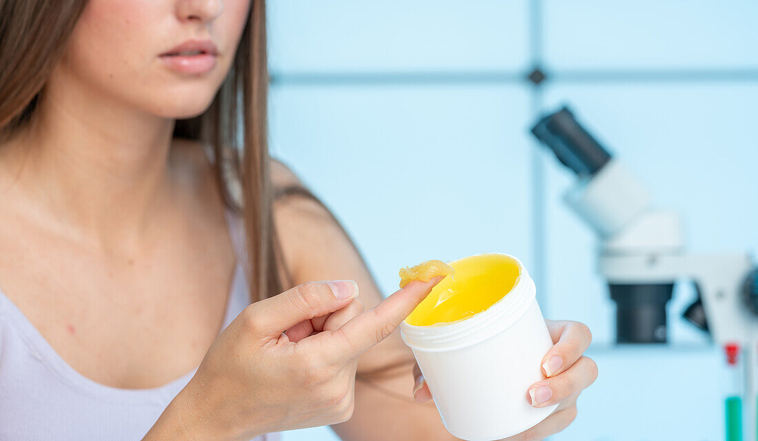 Woman using ointment from jar