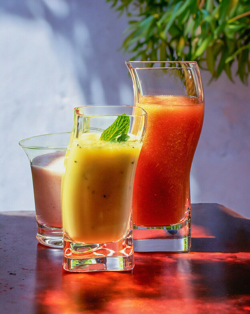 Three smoothies - strawberry smoothie, kiwi smoothie and apricot-pear smoothie