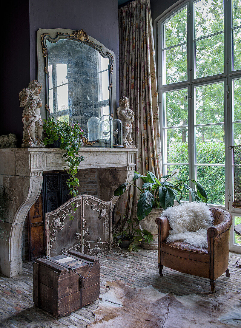 Vintage-Wohnzimmer mit Kamin, Spiegel, Lederstuhl und großen Fenstern