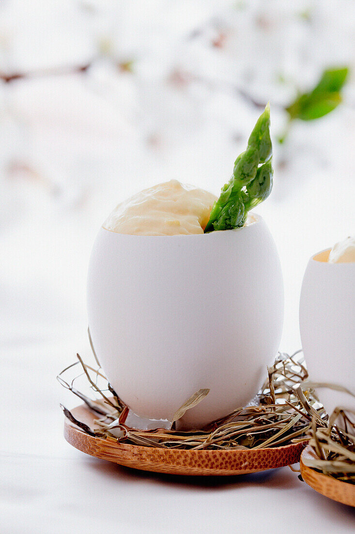 Scrambled eggs with green asparagus served in an eggshell