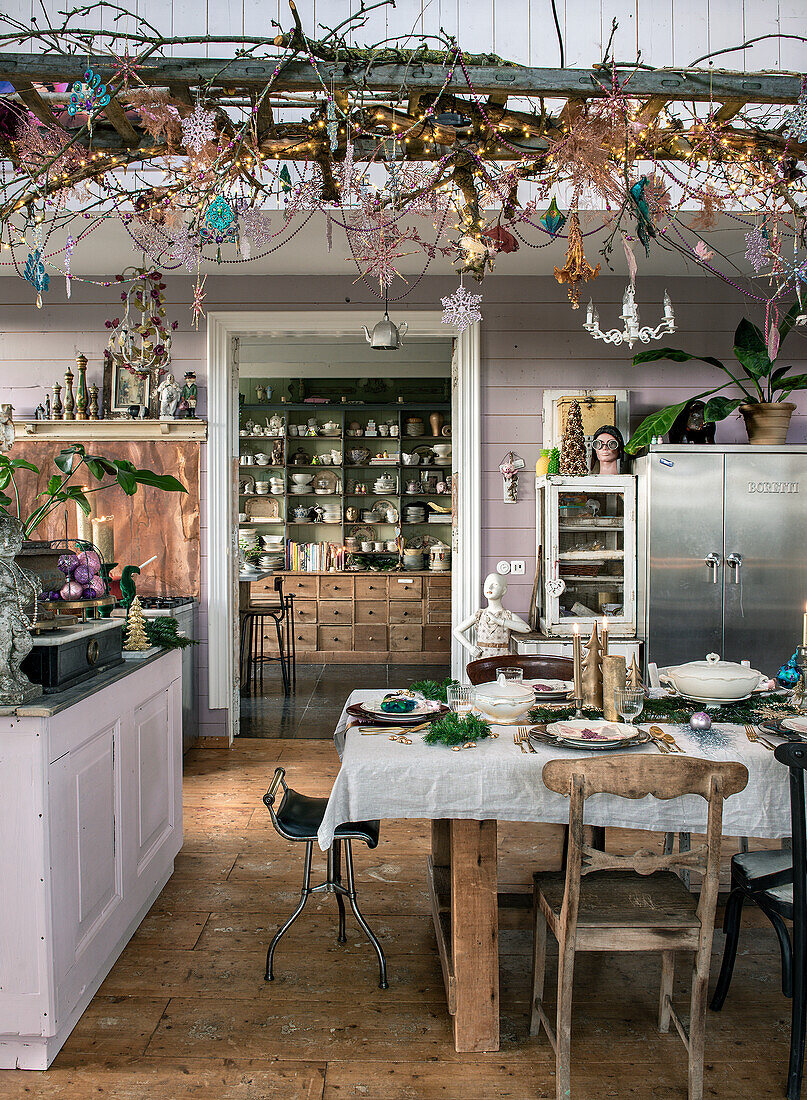 Rustic dining room with wooden table and decorated wooden ladder on the ceiling