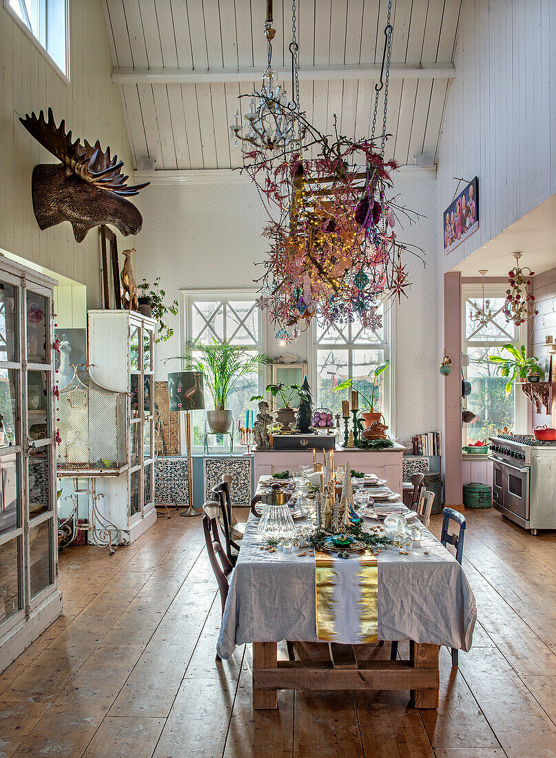 Esszimmer im Landhausstil mit hohem Dach, rustikalem Holztisch und bunter Weihnachtsdekoration